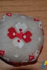 un biscornu en lin ,coton rouge et blanc